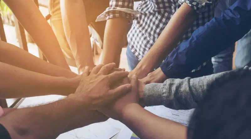 A group of people joining their hands as a team.