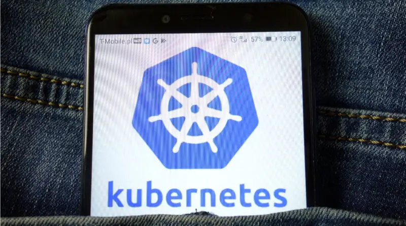 A mobile phone in a jean pocket with the Kubernetes logo in its screen.