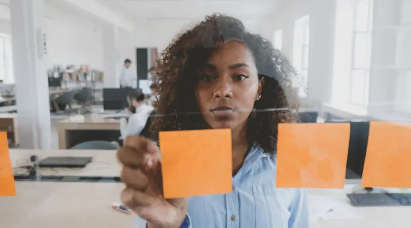 A woman pasting a post it.