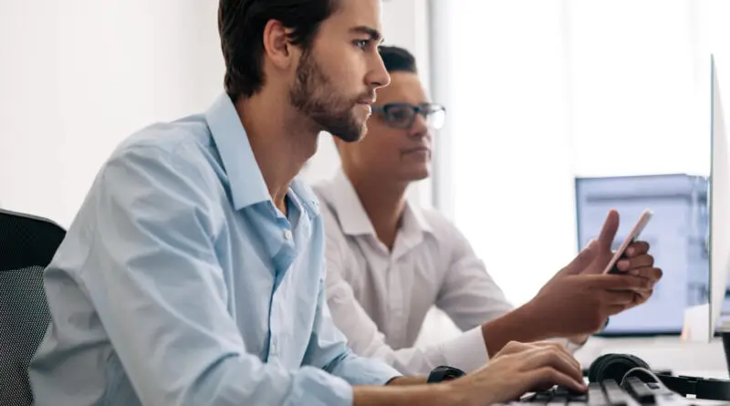 two men working on computers