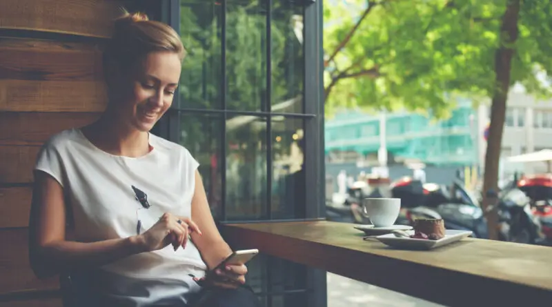 A woman enjoying her user experience of her mCommerce app on her phone.