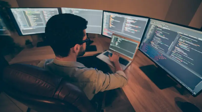 man working with multiple computer screens